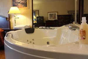 尼亚加拉瀑布尼亚加拉丽思汽车旅馆的浴室内设有带水龙头的白色浴缸