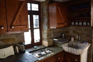 PalaiókastronTraditional Greek Cottage的厨房配有木制橱柜和炉灶烤箱。