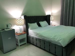 IbrāTafadal的一间卧室配有一张大床和一个床头柜