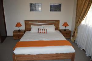 BokongMotebong Lodge的一间卧室配有一张大床,桌子上放着两盏灯