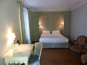 贝桑松莱斯邓思查尔斯昆特酒店的酒店客房带一张床、一张桌子和椅子