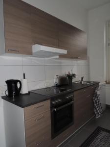 盖尔森基兴Zentrales Apartment in Gelsenkirchen的厨房配有木制橱柜和炉灶烤箱。