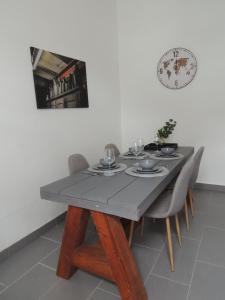盖尔森基兴Zentrales Apartment in Gelsenkirchen的餐桌、椅子和墙上的时钟