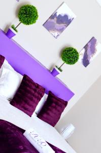 姆巴巴内Rehoboth Mountain Suites的一间卧室设有紫色的墙壁和一张带紫色枕头的床