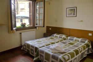 吉塔里亚赫塔里亚诺膳食公寓的一间卧室设有两张床和两个窗户。