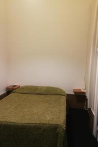 里斯本南部旅馆的一间卧室设有绿色的床和白色的墙壁