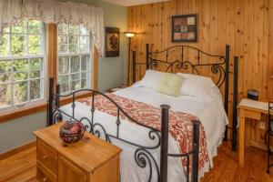 加利纳Cloran Mansion Bed & Breakfast的一间卧室配有一张床、一张书桌和两个窗户。