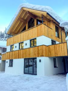 湖城Chalet See Tirol - Ischgl/Kappl的雪中带木屋顶的房子