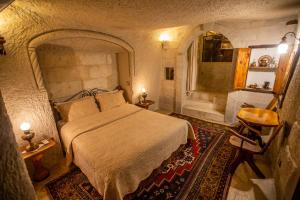 格雷梅古座洞穴酒店的一间带大床的卧室和一间浴室