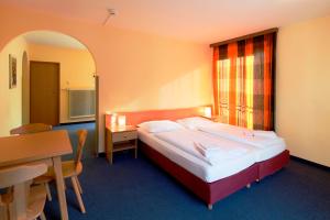 巴德加斯坦科纳欧洲青年酒店的配有一张床、一张桌子和一张桌子的酒店客房