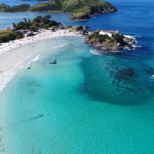 卡波布里奥Cobertura em cabo frio的和水中的人一起欣赏海滩的空中景色