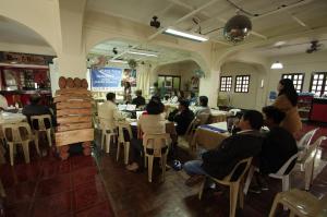 巴斯科Batanes Seaside Lodge & Restaurant的一群坐在餐厅桌子上的人