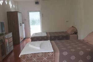 涛岛Mint Guesthouse的酒店客房设有两张床和电视。