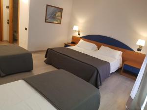 Sommariva Perno罗埃罗公园酒店的酒店客房,设有两张床和一张四柱床