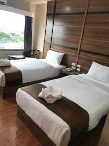 合艾ATK Garden Hills的酒店客房设有两张床和窗户。