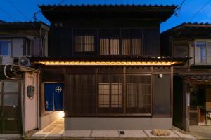 金泽Ainotsuji Machiya House的一座房子,上面有门和灯