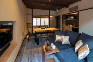 金泽Ainotsuji Machiya House的客厅配有蓝色的沙发和桌子