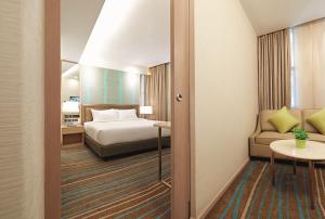 吉隆坡吉隆坡丽悦酒店的配有一张床和一把椅子的酒店客房