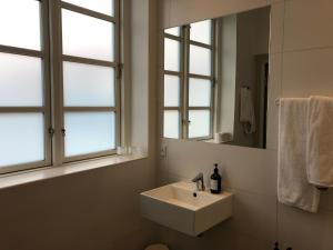 洛肯Hotel Løkken Strand的白色浴室设有水槽和2扇窗户