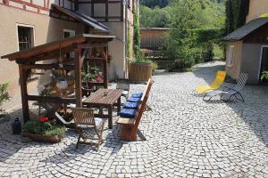 GrochwitzStöckigtsmühle的砖地庭院配有木桌和椅子
