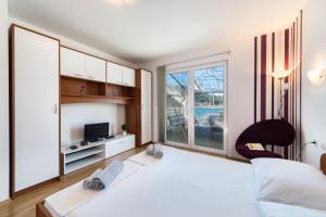 普洛切Apartments Barbir的卧室配有一张白色大床和电视。