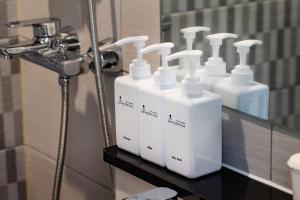 首尔Five hotel Jongno的浴室内柜台上的一组白皂液器