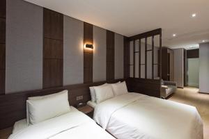 釜山Notte La Mia Hotel的一间酒店客房,房间内设有两张床