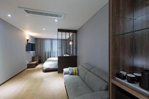 釜山Notte La Mia Hotel的客厅配有沙发和1张床