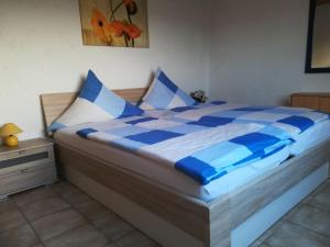 阿滕多恩Flat with private pool in Sauerland的一张带蓝色和白色床单及枕头的床