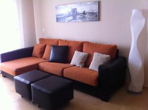 拉曼加戴尔马尔梅纳CORMORANT SUITE, sea terrace & pools的客厅配有橙色沙发和白色花瓶