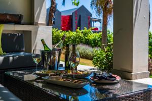 斯泰伦博斯Kunjani Villas的露台上配有带酒杯和食物的桌子