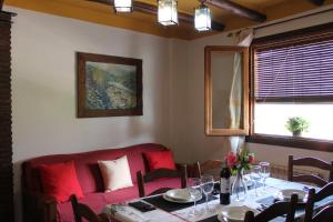 卡皮雷拉Apartamentos Rurales Rosendo: "La Pimienta"的一间带桌子和红色沙发的用餐室