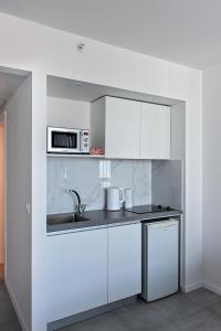 内坦亚Netanya SeaView ApartHotel的白色的厨房配有水槽和微波炉