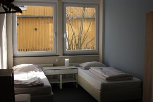 汉堡阿霍伊宾馆的客房设有两张床、一张桌子和两个窗户。