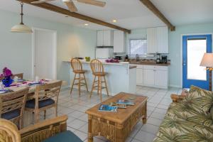 ContantCoconut Coast Villas的厨房以及带桌椅的起居室。
