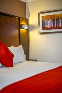 金斯林金斯林品质酒店的酒店客房,配有一张带红色枕头的床