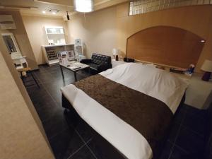 名古屋魅力酒店（仅限成人）的一间带大床的卧室和一间客厅