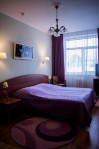 特维尔奥克特亚布斯卡亚酒店的一间卧室配有一张大床和紫色床罩
