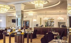 弗罗茨瓦夫弗罗茨瓦夫加斯科高级酒店的餐厅设有桌椅和吊灯。