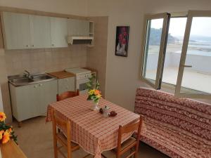 加利波利Appartamenti La Spiaggia的一间带桌子和沙发的小厨房