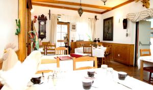 格拉茨祖尔斯特里斯特博酒店的一间带桌椅和时钟的用餐室