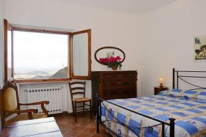 圣吉米纳诺La Torre Nomipesciolini的一间卧室配有一张床、一个梳妆台和一扇窗户。