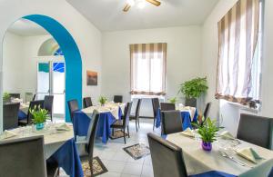 伊斯基亚Hotel Terme Miramonte e Mare的一间带桌椅的餐厅以及蓝色拱门