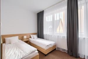 华沙帕特雷酒店的一间卧室设有两张床和窗户。