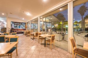派西亚国敦大酒店&度假村 - 岛屿湾的餐厅设有桌椅和窗户。