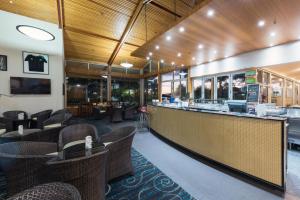 派西亚国敦大酒店&度假村 - 岛屿湾的餐厅设有酒吧和桌椅