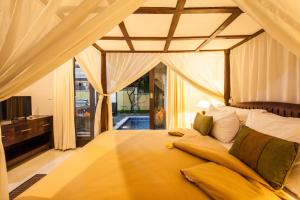 勒吉安苏里亚马斯别墅酒店的一间卧室设有一张大黄床和窗户