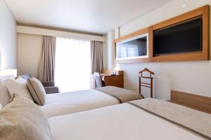 蓬塔德尔加达蓬塔德尔加达康福特茵酒店的酒店客房设有两张床和一台平面电视。