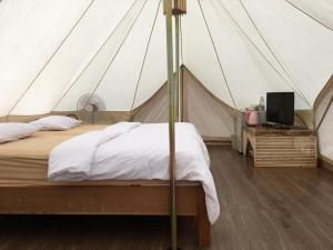 高兰兰塔当地小屋度假村的帐篷内一间卧室,配有一张床