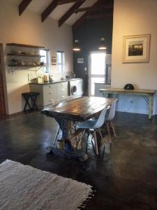 克尼斯纳Stylish Country Cottage, Solar panelled in Knysna的一间厨房,内设一张木桌和椅子